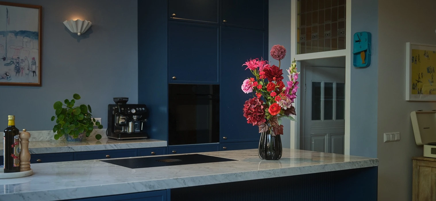donkere keuken met vaas met rode roze bloemen van TICA
