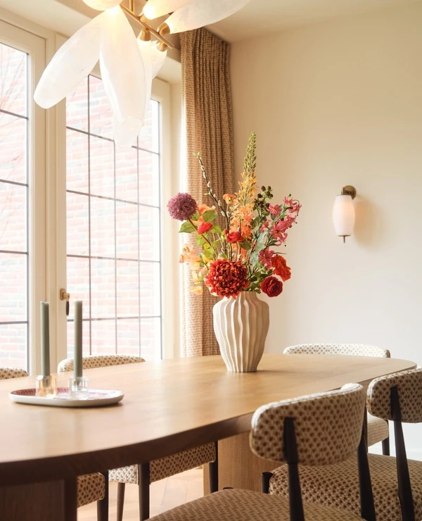 beige keuken met vaas met roze geel groene oranje bloemen op het aanrecht van TICA